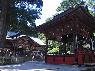 境内。右に神楽殿。左奥に拝殿。拝殿の左右には御神木の杉が立つ。